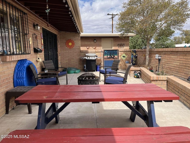 view of patio / terrace featuring an outdoor fire pit, a grill, and fence