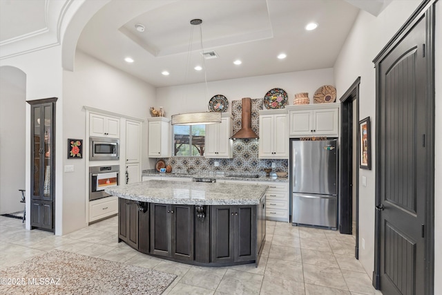 4544 N Camino Real, Tucson, AZ 85718 - kitchen featuring a tray ceiling, wall chimney exhaust hood, arched walkways, backsplash, and stainless steel appliances