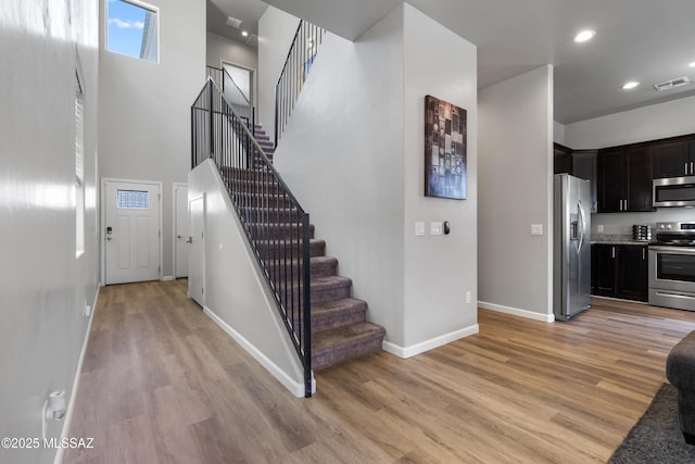 156 E Stone Ct, Tucson, AZ 85705 - stairway with wood finished floors, baseboards, recessed lighting, and a high ceiling