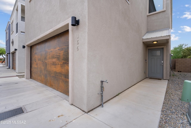 156 E Stone Ct, Tucson, AZ 85705 - doorway to property with stucco siding, a garage, and metal roof