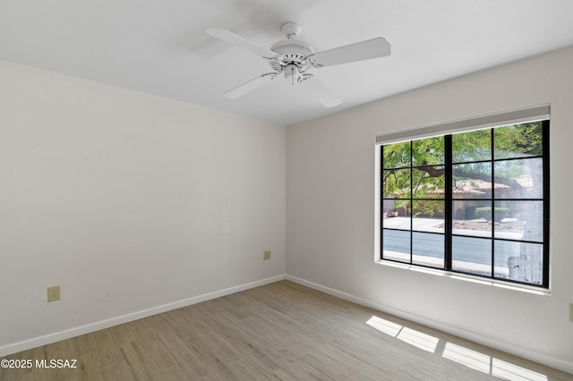 spare room with light wood-style floors, baseboards, and ceiling fan