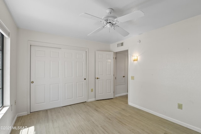 unfurnished bedroom with a closet, visible vents, baseboards, and light wood-style flooring