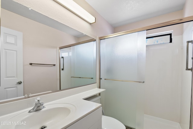 full bath featuring a shower stall, vanity, and toilet