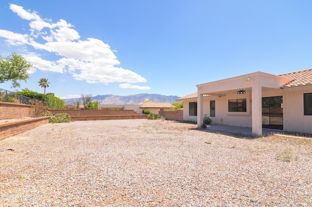 view of yard featuring a mountain view, a patio area, and fence