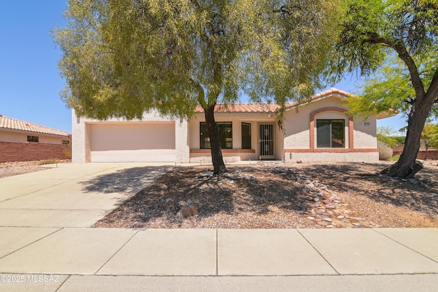 mediterranean / spanish house featuring fence, an attached garage, driveway, stucco siding, and a tiled roof