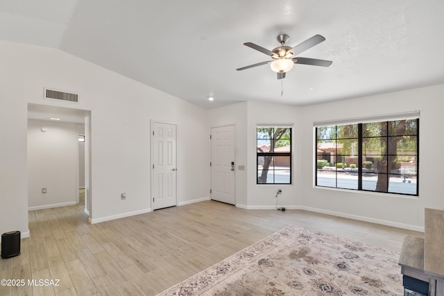 interior space with lofted ceiling, baseboards, light wood finished floors, ceiling fan, and visible vents