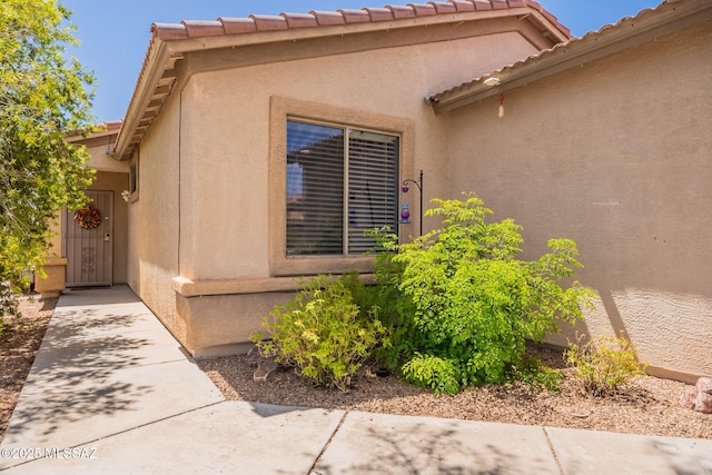 12445 N Crimson Vista Dr, Marana, AZ 85658 - view of exterior entry with a tiled roof and stucco siding