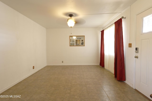 unfurnished room with ceiling fan and baseboards