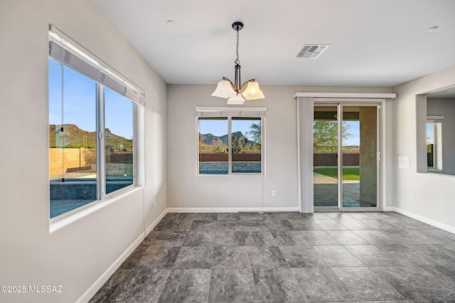 8695 W Cadwell Way, Marana, AZ 85653 - spare room featuring baseboards, stone finish floors, and a chandelier