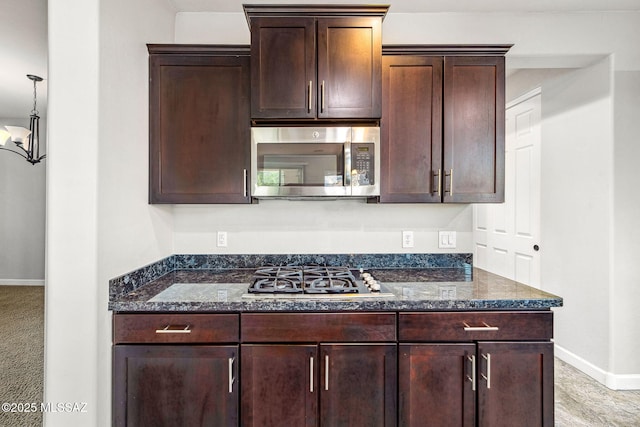 8695 W Cadwell Way, Marana, AZ 85653 - kitchen with appliances with stainless steel finishes, dark stone counters, baseboards, and dark brown cabinetry