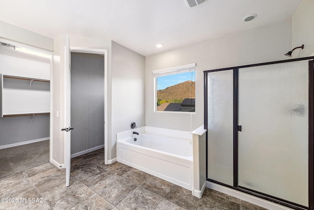 8695 W Cadwell Way, Marana, AZ 85653 - bathroom with a shower stall, a garden tub, baseboards, and a spacious closet