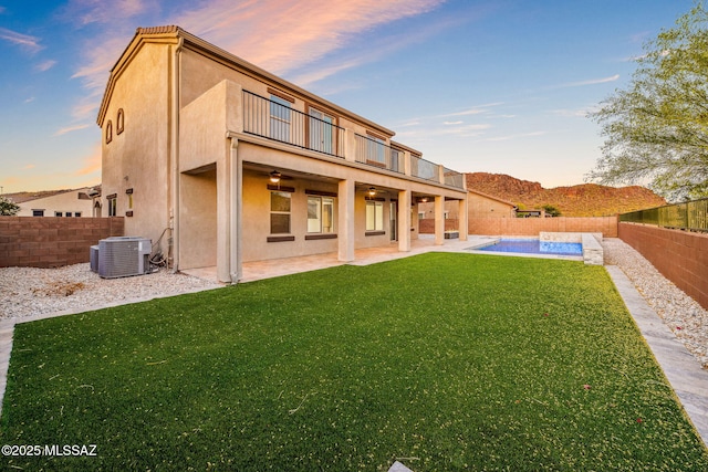 8695 W Cadwell Way, Marana, AZ 85653 - back of house at dusk with a balcony, central air condition unit, a patio area, ceiling fan, and stucco siding