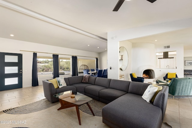 living area with light tile patterned flooring, visible vents, recessed lighting, a large fireplace, and a ceiling fan