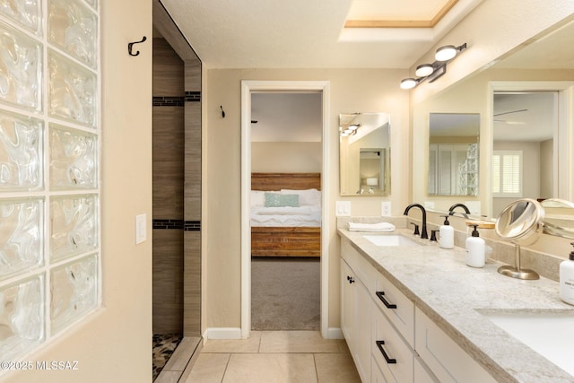 bathroom with a sink, double vanity, connected bathroom, and tile patterned floors