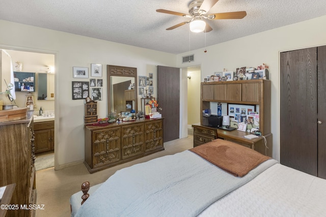 575 N Robles Rd, Oracle, AZ 85623 - bedroom with a textured ceiling, light colored carpet, a closet, connected bathroom, and ceiling fan