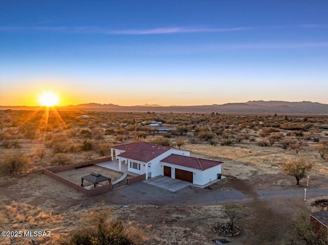 aerial view at dusk with a mountain view, a rural view, and view of desert