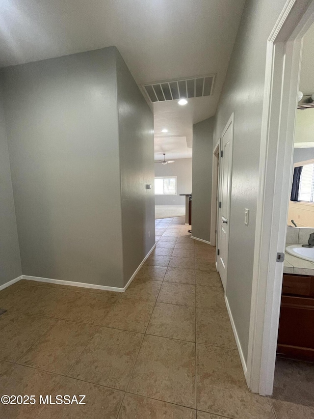 9454 E Lanterra Ct, Tucson, AZ 85710 - corridor featuring light tile patterned floors, baseboards, visible vents, and a sink
