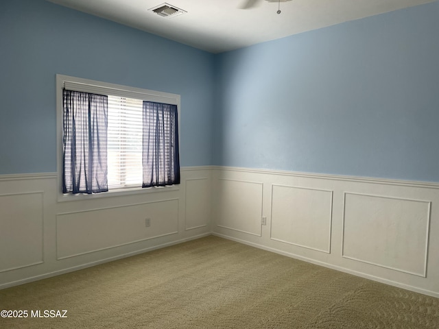 9454 E Lanterra Ct, Tucson, AZ 85710 - carpeted spare room featuring ceiling fan, a decorative wall, wainscoting, and visible vents