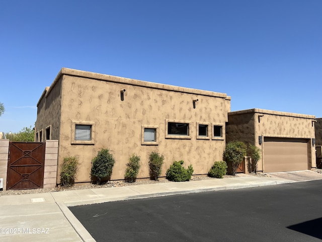 9454 E Lanterra Ct, Tucson, AZ 85710 - view of front of property with an attached garage, stucco siding, and a gate