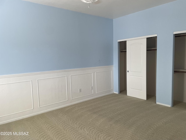 9454 E Lanterra Ct, Tucson, AZ 85710 - unfurnished bedroom featuring carpet, a decorative wall, and wainscoting