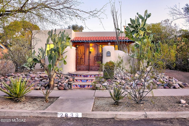 view of front facade with stucco siding and a tile roof