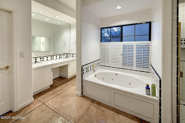 full bathroom featuring a sink, a tub with jets, recessed lighting, tile patterned floors, and double vanity