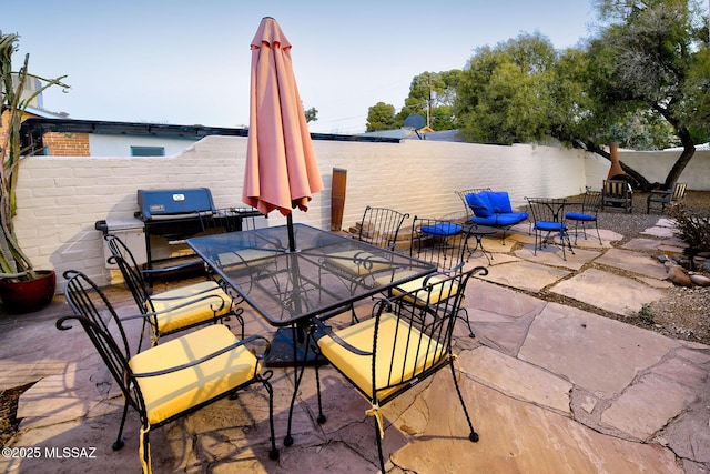view of patio with a fenced backyard, area for grilling, and outdoor dining area