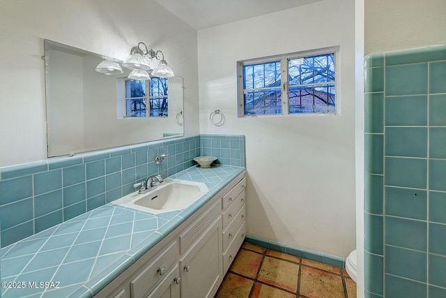 bathroom featuring toilet, tasteful backsplash, and vanity