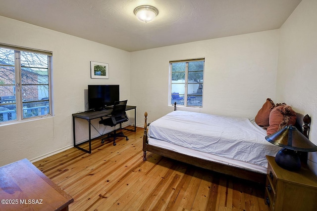 bedroom with baseboards and hardwood / wood-style floors