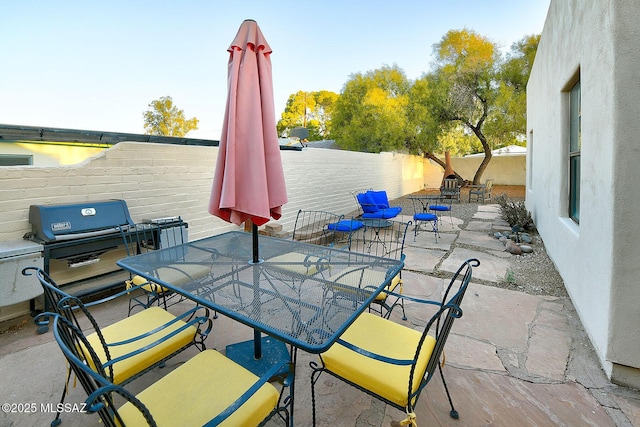 view of patio featuring area for grilling, outdoor dining area, and a fenced backyard