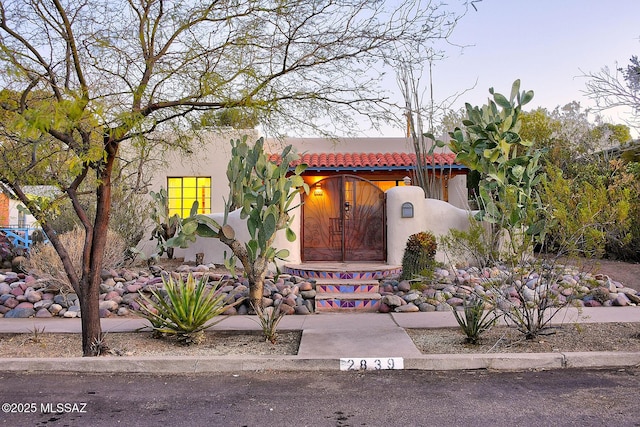 view of front facade with stucco siding and a tile roof