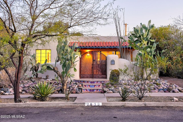 mediterranean / spanish house with a tiled roof and stucco siding