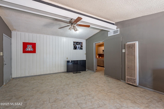 2220 E 35th St, Tucson, AZ 85713 - spare room with a heating unit, a textured ceiling, a ceiling fan, and wood walls