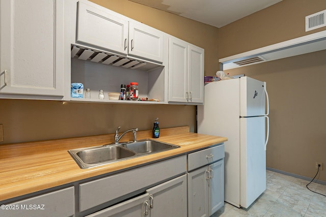 2220 E 35th St, Tucson, AZ 85713 - kitchen featuring a sink, freestanding refrigerator, open shelves, and white cabinets