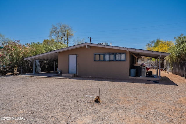 2220 E 35th St, Tucson, AZ 85713 - rear view of house with stucco siding, fence, and an attached carport