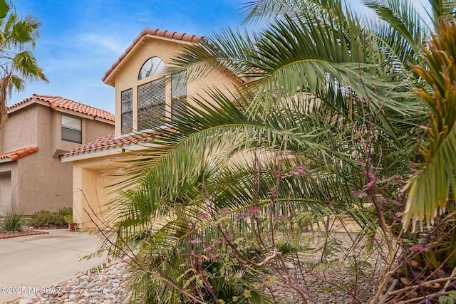 4755 W Lessing Ln, Tucson, AZ 85742 - view of front of house featuring a tiled roof, stucco siding, driveway, and an attached garage