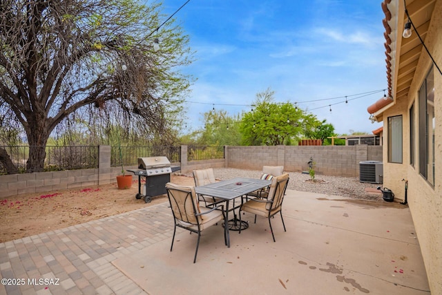 4755 W Lessing Ln, Tucson, AZ 85742 - view of patio / terrace with a grill, outdoor dining space, a fenced backyard, and central AC