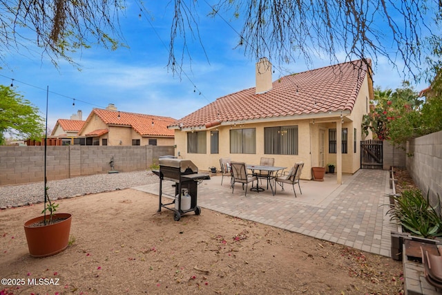 4755 W Lessing Ln, Tucson, AZ 85742 - rear view of house featuring a tiled roof, a fenced backyard, stucco siding, a patio area, and a gate