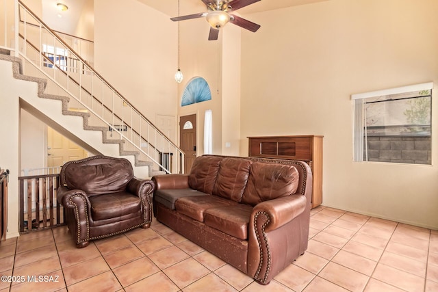 4755 W Lessing Ln, Tucson, AZ 85742 - living room featuring a high ceiling, ceiling fan, light tile patterned floors, and stairway