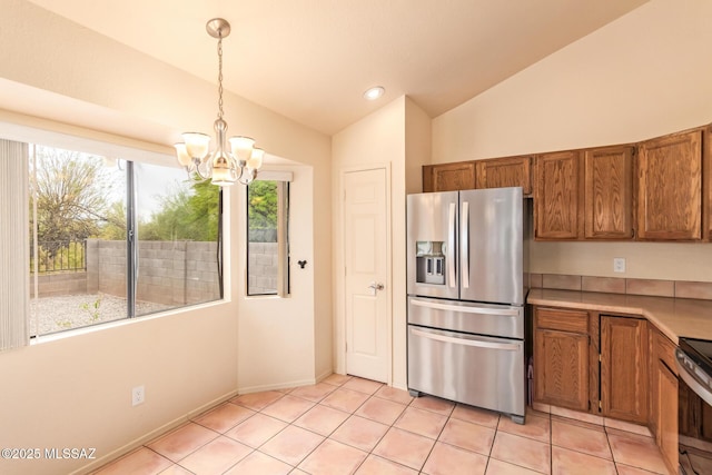 4755 W Lessing Ln, Tucson, AZ 85742 - kitchen with appliances with stainless steel finishes, vaulted ceiling, brown cabinets, a chandelier, and light countertops