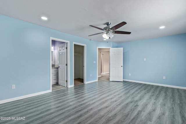 1239 N Beverly Ave, Tucson, AZ 85712 - unfurnished bedroom featuring wood finished floors, baseboards, a spacious closet, and recessed lighting