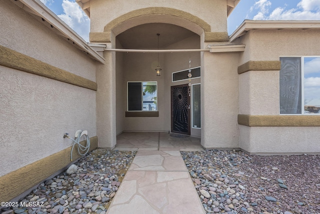 entrance to property featuring stucco siding
