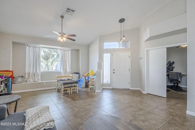 entrance foyer with lofted ceiling, ceiling fan, tile patterned floors, and visible vents