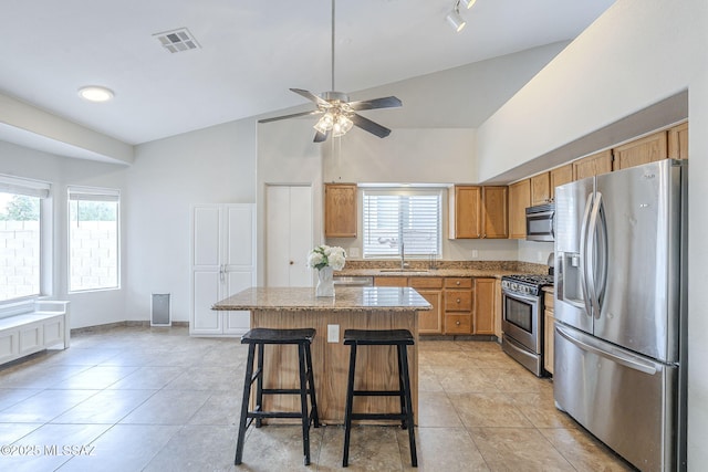 kitchen featuring a sink, high vaulted ceiling, visible vents, a center island, and appliances with stainless steel finishes