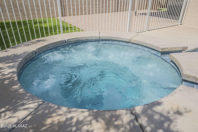 view of pool featuring an in ground hot tub and fence