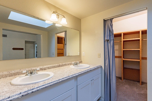 full bath with visible vents, double vanity, and a sink