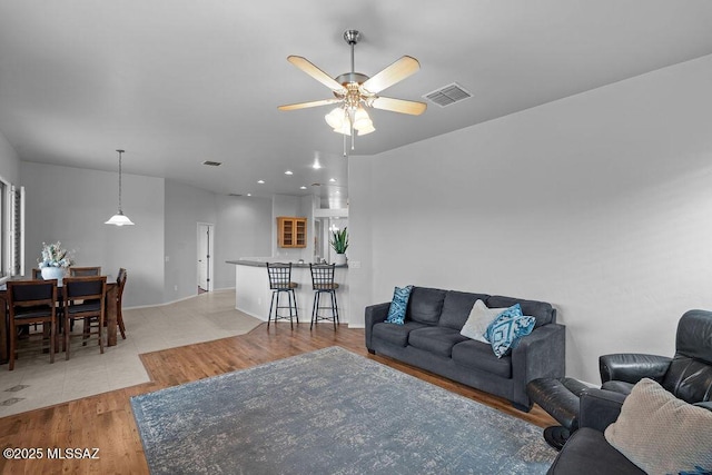 living area featuring light wood-style flooring and a ceiling fan