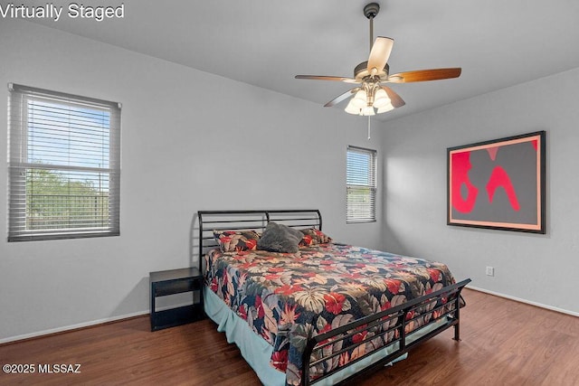 bedroom featuring baseboards, wood finished floors, and a ceiling fan