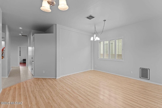 spare room with a chandelier, baseboards, light wood-type flooring, and recessed lighting