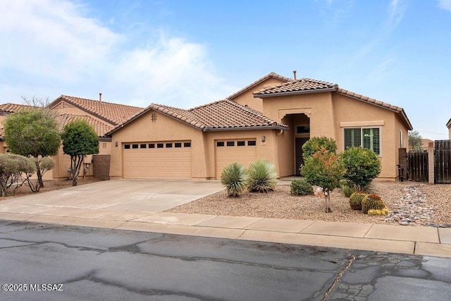 mediterranean / spanish house featuring an attached garage, stucco siding, concrete driveway, and a tile roof